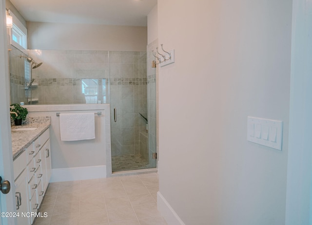 bathroom with vanity, a shower with shower door, and tile patterned floors