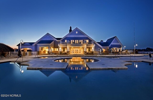 pool at dusk with a patio area