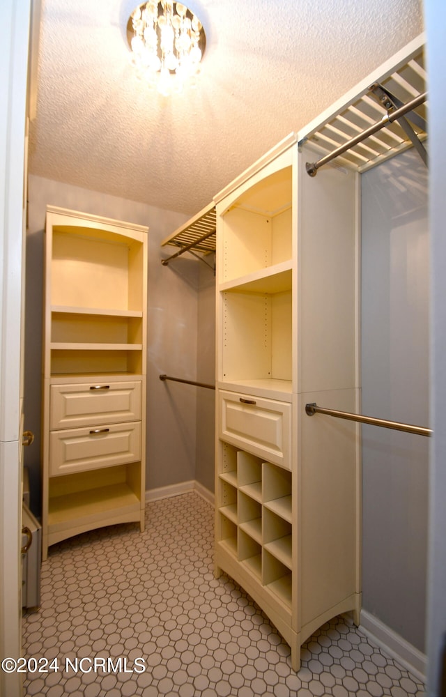 walk in closet featuring an inviting chandelier