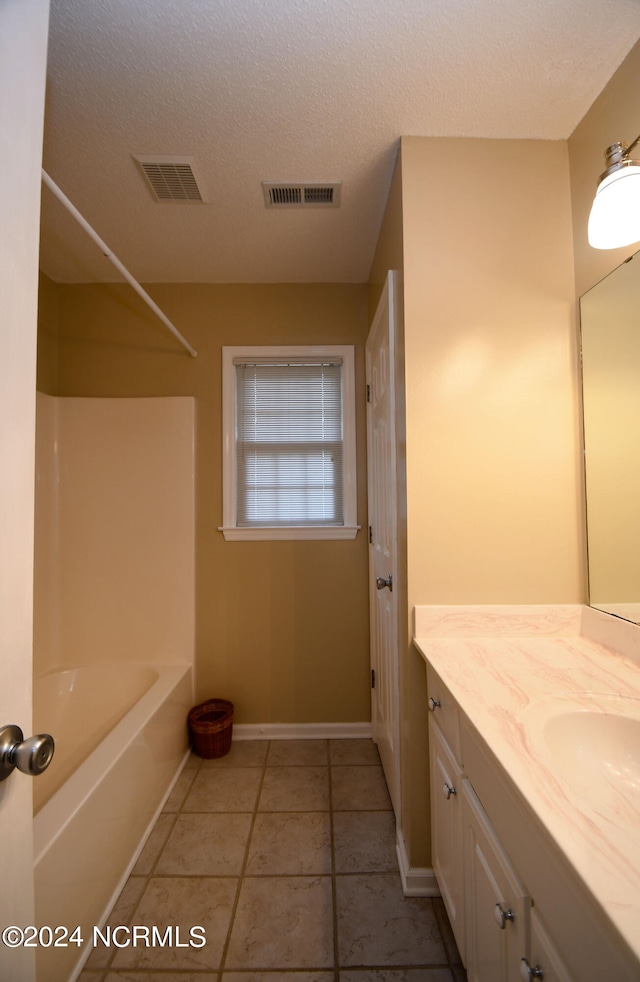 bathroom featuring shower / tub combination, vanity, a textured ceiling, and tile patterned floors