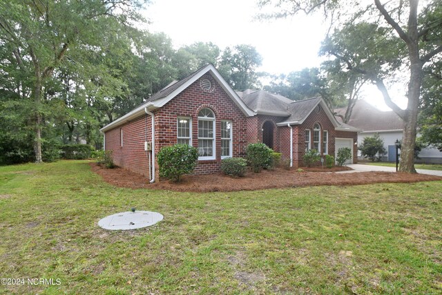 view of front of property featuring a front yard and a garage