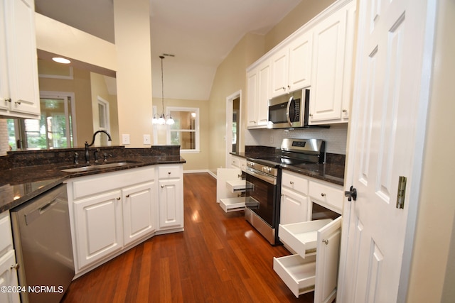 kitchen with hanging light fixtures, white cabinets, dark hardwood / wood-style flooring, stainless steel appliances, and sink