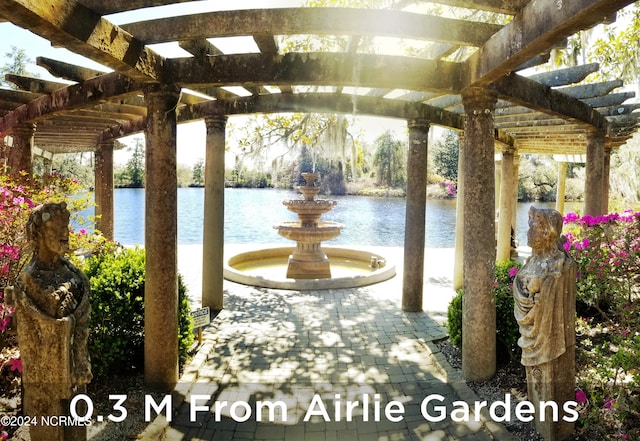 view of patio / terrace with a pergola and a water view