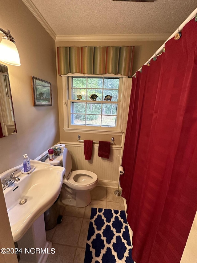 full bath with a textured ceiling, crown molding, toilet, curtained shower, and tile patterned flooring