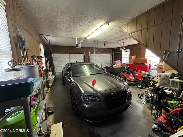 garage featuring a garage door opener and wooden walls