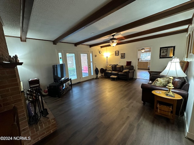 living room featuring a wealth of natural light, beam ceiling, dark hardwood / wood-style floors, and a textured ceiling