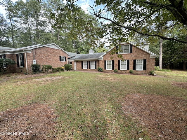 traditional home with brick siding and a front lawn