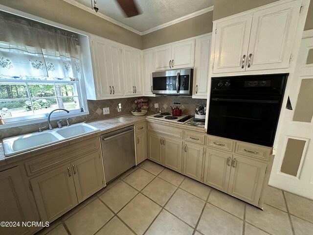 kitchen featuring decorative backsplash, ornamental molding, sink, light tile patterned flooring, and appliances with stainless steel finishes