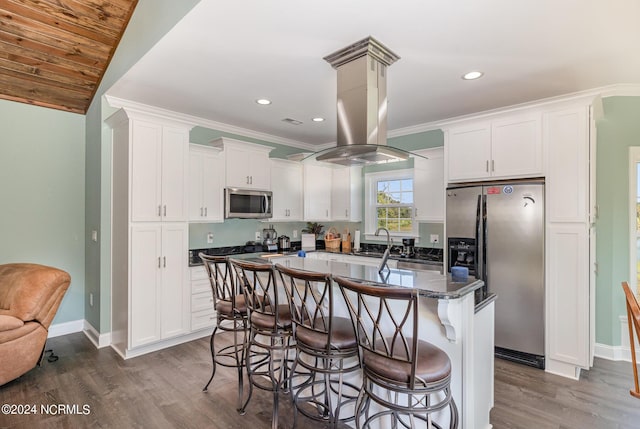 kitchen featuring a center island, white cabinets, lofted ceiling, and appliances with stainless steel finishes