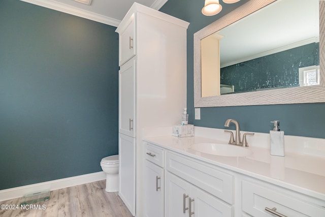 bathroom with vanity, hardwood / wood-style flooring, toilet, and ornamental molding