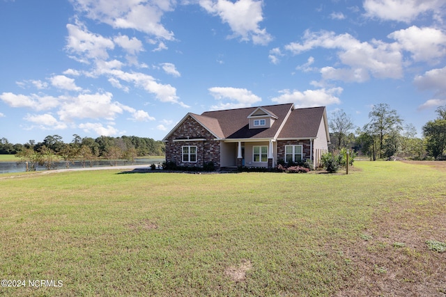 view of front of home with a water view and a front lawn