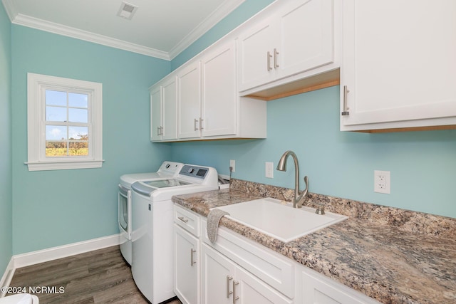 clothes washing area with sink, cabinets, dark hardwood / wood-style floors, crown molding, and washer and dryer