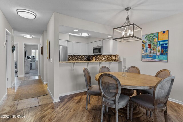 dining space featuring a notable chandelier and light hardwood / wood-style floors