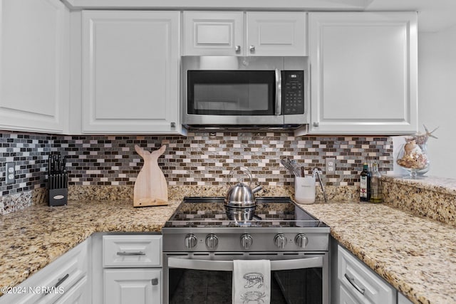 kitchen with white cabinets, appliances with stainless steel finishes, and tasteful backsplash