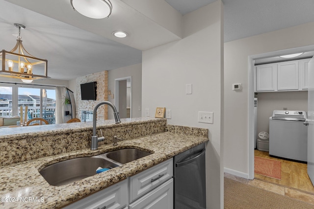 kitchen with white cabinetry, dishwasher, washer / dryer, and light stone counters