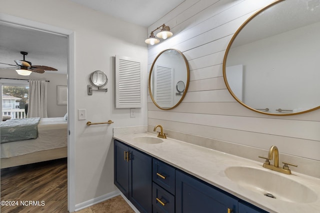 bathroom with ceiling fan, vanity, wood walls, and hardwood / wood-style flooring