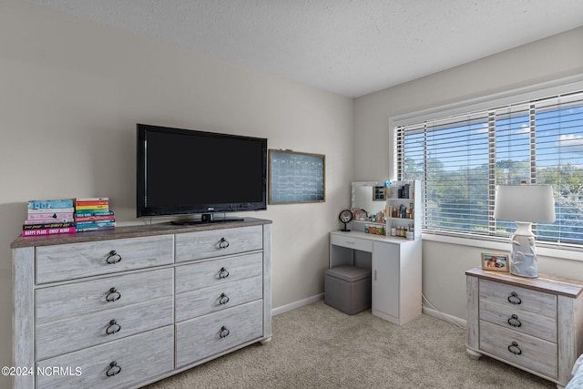 bedroom featuring a textured ceiling and light colored carpet