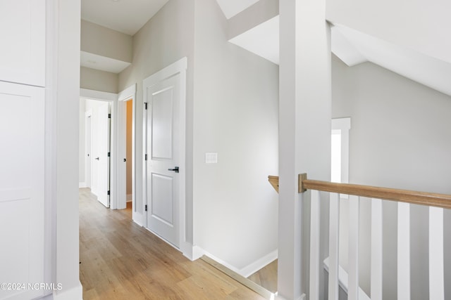 hall featuring lofted ceiling and light hardwood / wood-style floors