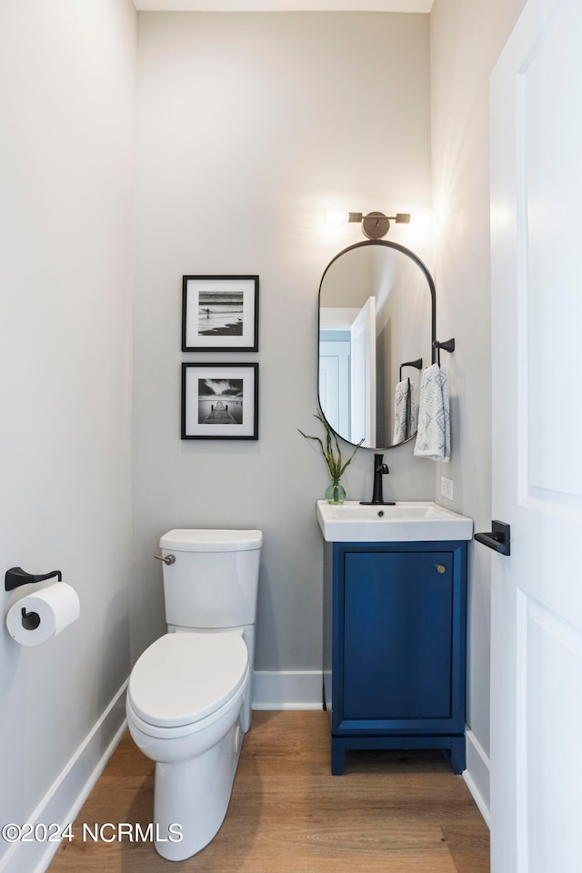 bathroom featuring hardwood / wood-style flooring, vanity, and toilet