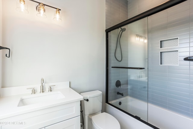 full bathroom with vanity, toilet, and bath / shower combo with glass door