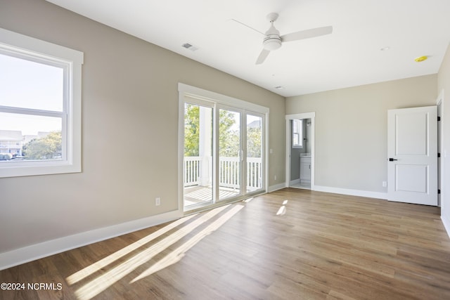 spare room featuring baseboards, visible vents, wood finished floors, and ceiling fan