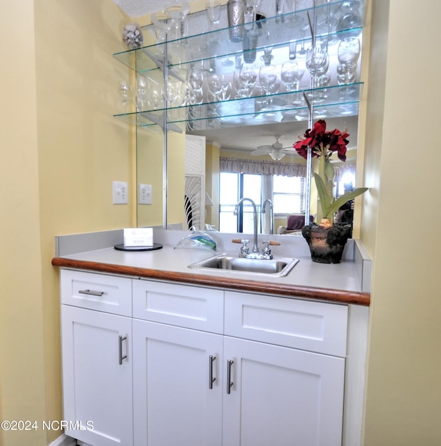 bar with a sink and a ceiling fan