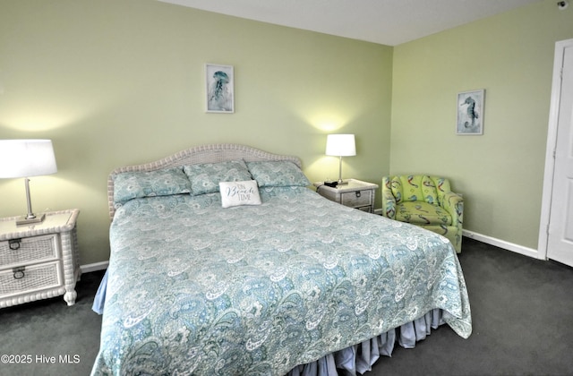 bedroom with dark carpet and baseboards