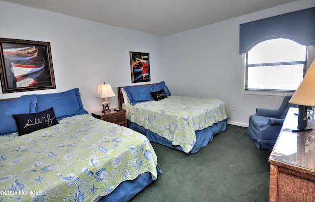 bedroom with baseboards and dark colored carpet