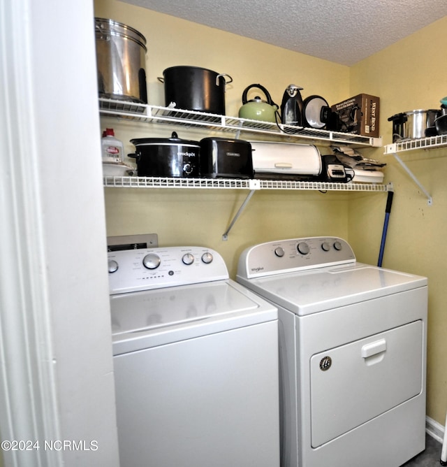 laundry room with washing machine and dryer, laundry area, and a textured ceiling