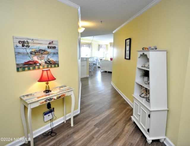 hall with baseboards, ornamental molding, and wood finished floors