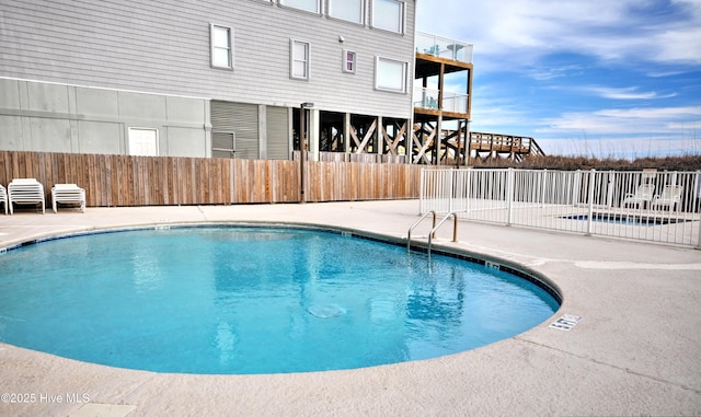 community pool featuring fence and a patio