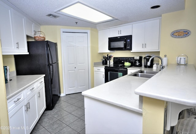 kitchen featuring black appliances, a sink, light countertops, and white cabinetry