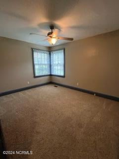 carpeted spare room with ceiling fan