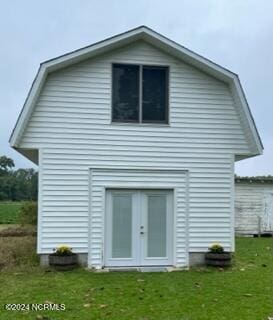 back of property featuring french doors and a lawn