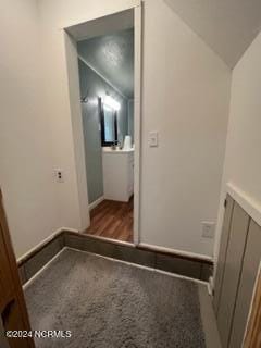 interior space with dark colored carpet and vaulted ceiling