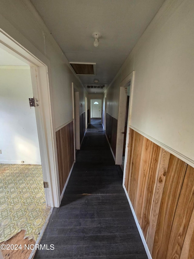 corridor featuring wood walls and dark hardwood / wood-style flooring