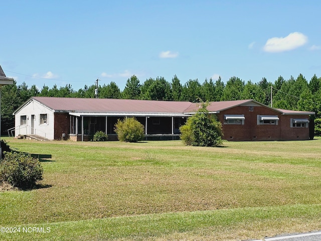 view of front of house featuring a sunroom and a front lawn