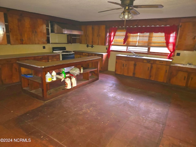 kitchen with ceiling fan, white gas range oven, and wall chimney range hood