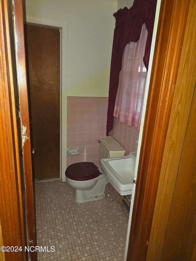 bathroom with sink, tile walls, toilet, and tile patterned floors