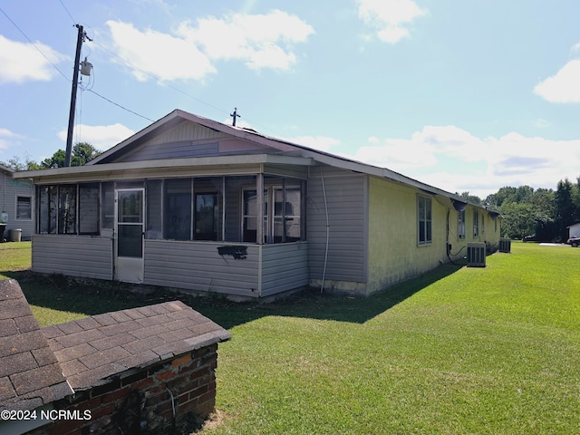 exterior space featuring a sunroom, central AC, and a front yard