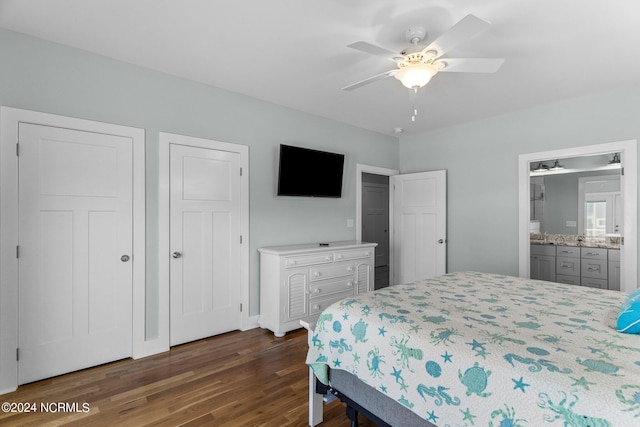 bedroom with two closets, dark hardwood / wood-style floors, ceiling fan, and ensuite bathroom