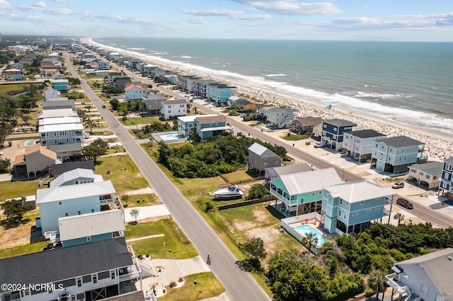 birds eye view of property with a water view and a beach view