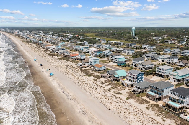 birds eye view of property with a water view and a beach view