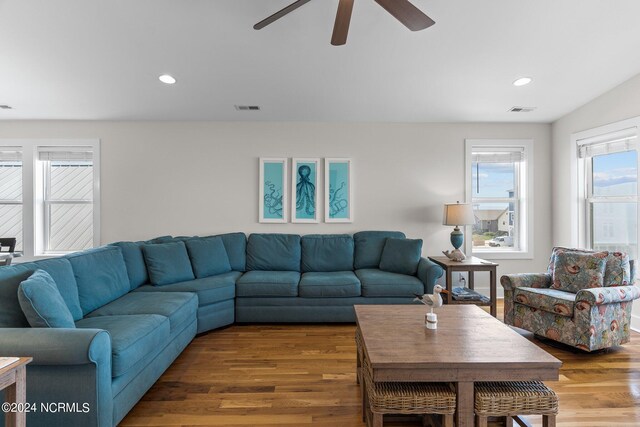 living room with ceiling fan and dark wood-type flooring