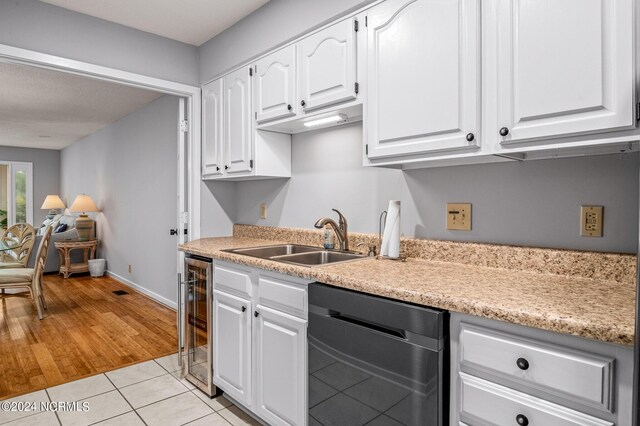 kitchen featuring black dishwasher, wine cooler, sink, white cabinets, and light hardwood / wood-style flooring