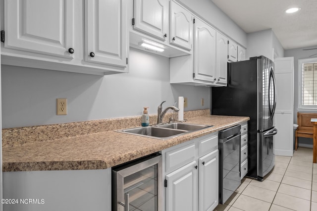 kitchen with white cabinets, light tile patterned floors, sink, beverage cooler, and dishwasher