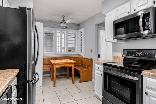 kitchen featuring white cabinetry, ceiling fan, appliances with stainless steel finishes, and light tile patterned floors