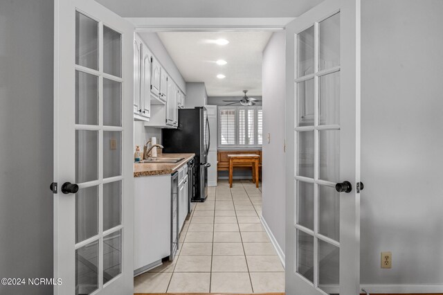 kitchen featuring white cabinetry, light tile patterned floors, ceiling fan, french doors, and sink