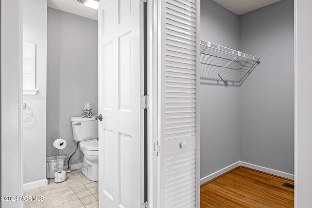 bathroom featuring wood-type flooring and toilet