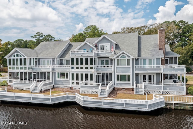 back of property featuring a balcony and a deck with water view